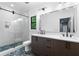 Bathroom featuring double vanity, modern fixtures, glass shower, and decorative floor tiles at 575 Indian Hills Pkwy, Marietta, GA 30068