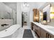 Bright bathroom features a freestanding tub, an open shower, dual vanities, quartz countertops, and sleek, modern lighting at 575 Indian Hills Pkwy, Marietta, GA 30068