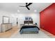 Spacious bedroom boasts a red accent wall, hardwood floors, and a comfortable bed and stylish decor at 575 Indian Hills Pkwy, Marietta, GA 30068