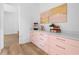 Butler's pantry with pink cabinets, snack station, quartz countertops and modern hardware at 575 Indian Hills Pkwy, Marietta, GA 30068
