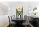 Bright dining room featuring a black table and chairs beneath a glamorous chandelier and large windows at 575 Indian Hills Pkwy, Marietta, GA 30068