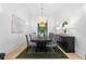 Bright dining room featuring a black table and chairs beneath a glamorous chandelier and large windows at 575 Indian Hills Pkwy, Marietta, GA 30068