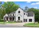 Modern farmhouse exterior showcasing white siding, a black roof, and a convenient attached two-car garage at 575 Indian Hills Pkwy, Marietta, GA 30068