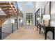 Grand foyer featuring light hardwood floors, a modern staircase, elegant mirrors, and black steel-framed doors at 575 Indian Hills Pkwy, Marietta, GA 30068
