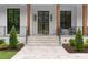 Charming front porch with stone stairs, modern railings, and a sleek, black-framed glass front door at 575 Indian Hills Pkwy, Marietta, GA 30068