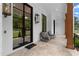 Relaxing front porch featuring stone flooring, brick accents, and comfortable seating with stylish light fixtures at 575 Indian Hills Pkwy, Marietta, GA 30068