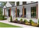 Inviting front porch with stone accents, wooden pillars, stylish seating, and landscaped garden beds at 575 Indian Hills Pkwy, Marietta, GA 30068