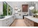 Bright kitchen featuring white cabinetry, an island with seating, and a large window with a view of the surrounding greenery at 575 Indian Hills Pkwy, Marietta, GA 30068