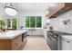 Modern kitchen with white cabinetry, a central island with seating, and a window with a view of the surrounding greenery at 575 Indian Hills Pkwy, Marietta, GA 30068