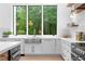 Bright kitchen featuring stainless steel appliances, white cabinets, and a large window with a view of the surrounding greenery at 575 Indian Hills Pkwy, Marietta, GA 30068