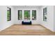 Bright living room featuring three large windows overlooking the backyard grilling and seating area at 575 Indian Hills Pkwy, Marietta, GA 30068