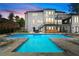 A rear view of a modern home showcasing a luxurious pool, outdoor bar and lounge area for entertainment at 575 Indian Hills Pkwy, Marietta, GA 30068
