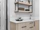 Close-up of a wet bar with floating shelves, sleek hardware, a quartz countertop, and warm, natural wood cabinets at 575 Indian Hills Pkwy, Marietta, GA 30068