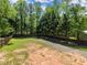 Gravel yard area in the backyard surrounded by trees, providing a private and natural setting at 5855 Willis Ln, Cumming, GA 30040