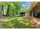 A large backyard offers mature trees and a shed. A car is seen parked under the covered side entry at 5855 Willis Ln, Cumming, GA 30040