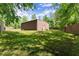 View of outbuilding surrounded by a well-maintained lawn, perfect for outdoor projects and storage at 5855 Willis Ln, Cumming, GA 30040