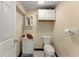 Half bathroom features a toilet and sink with a small cabinet, as well as a wall mirror and toilet paper holder at 5855 Willis Ln, Cumming, GA 30040