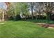 An expansive backyard featuring lush green grass and mature trees at 1215 Wynridge Xing, Alpharetta, GA 30005