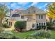 View of the home's rear exterior and landscaped backyard with lawn and plants at 1215 Wynridge Xing, Alpharetta, GA 30005