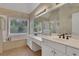 Bathroom with double sink vanity, large mirror, shower and soaking tub with a large window for natural light at 1215 Wynridge Xing, Alpharetta, GA 30005