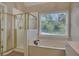 Bathroom featuring walk-in shower, soaking tub, and a window providing natural light and views of the outdoors at 1215 Wynridge Xing, Alpharetta, GA 30005