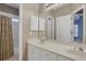 Bathroom with double vanity sinks, wallpaper, large mirror and walk-in shower with curtain at 1215 Wynridge Xing, Alpharetta, GA 30005