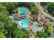 Aerial view of a luxurious community pool area with multiple pools, seating, and cabanas, surrounded by mature trees and landscaping at 1215 Wynridge Xing, Alpharetta, GA 30005
