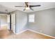 Bedroom featuring a modern ceiling fan, freshly painted gray walls, and adjacent hallway access at 1236 Stone Mountain Lithonia Rd, Lithonia, GA 30058
