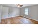 Bedroom with hardwood flooring features a ceiling fan, natural light, and white trim at 1236 Stone Mountain Lithonia Rd, Lithonia, GA 30058