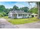 Home exterior featuring a white facade, black shutters, and well-manicured lawn at 1236 Stone Mountain Lithonia Rd, Lithonia, GA 30058