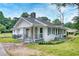 This home features a white exterior, stone chimney, covered porches, and a well-maintained yard at 1236 Stone Mountain Lithonia Rd, Lithonia, GA 30058