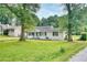 Charming white home with well-maintained front yard and mature trees at 1236 Stone Mountain Lithonia Rd, Lithonia, GA 30058