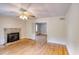 Cozy living room featuring hardwood floors, a stone fireplace, and an open doorway to another room at 1236 Stone Mountain Lithonia Rd, Lithonia, GA 30058