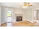 Living room with hardwood floors, a stone fireplace, ceiling fan and natural light streaming through the windows at 1236 Stone Mountain Lithonia Rd, Lithonia, GA 30058