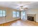 Bright living room featuring hardwood floors, a stone fireplace, and a ceiling fan at 1236 Stone Mountain Lithonia Rd, Lithonia, GA 30058