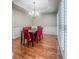 Elegant dining room featuring wood floors, plantation shutters, and a modern chandelier above a wooden table at 1485 Oglethorpe Run Ln, Suwanee, GA 30024