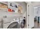 Functional laundry room features modern washer and dryer with storage shelves at 160 Cricket Ln, Alpharetta, GA 30009