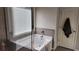 Soaking tub next to window with tiled walls and a towel hanging on the door at 118 Reunion Pl, Acworth, GA 30102