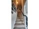 Carpeted stairway featuring a dark handrail and decorative wall art at 118 Reunion Pl, Acworth, GA 30102