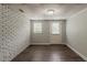 Finished basement with painted brick accent wall, new flooring, and exterior door at 2465 Hogan Rd, Atlanta, GA 30344