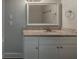 Bathroom vanity with white cabinets, granite countertop, and framed mirror at 2465 Hogan Rd, Atlanta, GA 30344