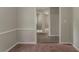 Hallway with neutral walls, white trim, carpet and view into other rooms at 2465 Hogan Rd, Atlanta, GA 30344