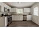 Bright kitchen featuring white cabinets, stainless steel appliances, and wood flooring at 2465 Hogan Rd, Atlanta, GA 30344