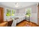 Sunlit bedroom showcasing hardwood floors, white wainscoting and serene ambiance at 6857 Womack Ct, Atlanta, GA 30360