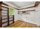 Functional laundry room with abundant shelving, a window for natural light, and hardwood floors at 6857 Womack Ct, Atlanta, GA 30360