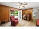 Cozy living room with wood paneled walls, access to deck, and a ceiling fan providing a relaxing atmosphere at 6857 Womack Ct, Atlanta, GA 30360