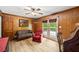 Inviting living room with wood paneling, a ceiling fan, and sliding door access to a private deck at 6857 Womack Ct, Atlanta, GA 30360