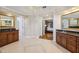 Bright bathroom with dual vanities and granite counters, a doorway to the main bedroom beyond at 205 Devon Downs Pl, Alpharetta, GA 30005