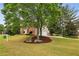 Scenic view of a brick home with an attached garage, nestled on a spacious lot with mature trees at 205 Devon Downs Pl, Alpharetta, GA 30005