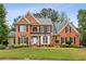 Charming two-story brick home featuring manicured landscaping and a welcoming front entrance at 205 Devon Downs Pl, Alpharetta, GA 30005